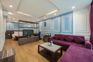 a living room with a purple couch and a bed at A25 Hotel - 21 Le Duc Tho in Hanoi