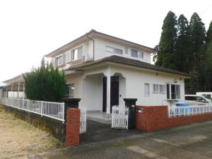 Ebinoえびのペンション的前面有白色围栏的白色房子