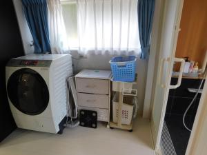 a washing machine in a room with a window at えびのペンション in Ebino
