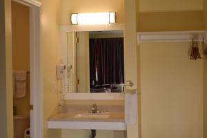 a bathroom with a sink and a mirror at Top Hill Motel in Saratoga Springs +7 photos