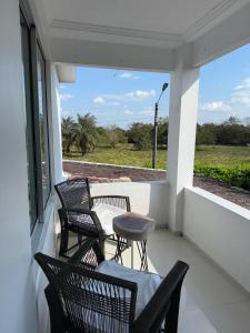 a porch with chairs and a table and a view at Yopo Resort in Pedregal