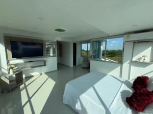 a bedroom with a bed and a flat screen tv at Yopo Resort in Pedregal