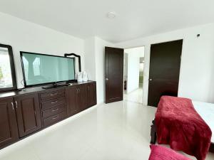a bedroom with a flat screen tv on a dresser at Yopo Resort in Pedregal