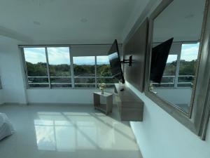 a white bathroom with a window and a sink at Yopo Resort in Pedregal +3 photos