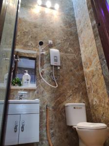a bathroom with a toilet and a sink and a mirror at Homestay Bota Sunrise in Kampung Bota Kiri