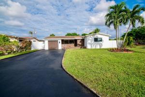 a house with a driveway in front of a yard at Cozy Corner Retreat in Miramar