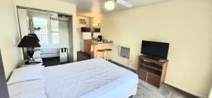 a bedroom with a white bed and a television at Twin Lakes Inn in Bull Shoals