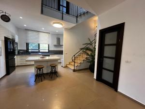a kitchen with a table and stools in a room at Super house- villa09 in Hod HaSharon