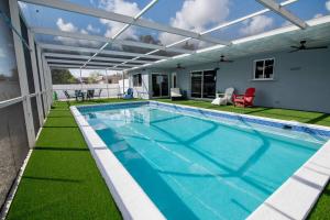una piscina con pérgola al lado de una casa en Luxury Retreat Near Hard Rock, en Joe Robbie Stadium Heliport