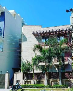 a motorcycle parked in front of a building with palm trees at jdm residency in Gurgaon