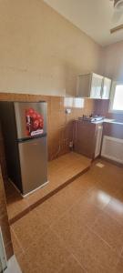a small kitchen with a refrigerator in a room at Al Rawas Son Apartment in Salalah
