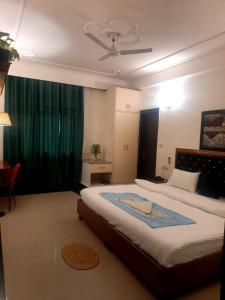 a bedroom with a large bed with a green curtain at jdm residency in Gurgaon