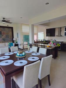 a dining room table with chairs and a kitchen at Casa Flamingos Coco in Mezcales