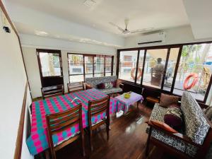 a living room with a table and chairs and a couch at Upper Deck Boathouse in Alleppey
