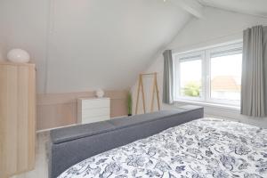 a bedroom with a bed and a large window at Chateau Noordwijk in Noordwijk