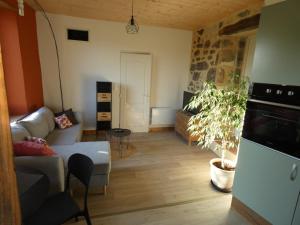 a living room with a couch and a plant at la ferme de la chanvriole in Mercuer +8 photos