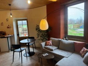 a living room with a couch and a table at la ferme de la chanvriole in Mercuer