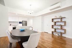 Una cocina y un comedor con mesa y sillas. en Little Collins Central Hideaway - Duplex Penthouse, en Melbourne