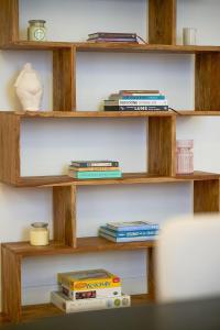 un estante de libros con libros y un jarrón. en Little Collins Central Hideaway - Duplex Penthouse, en Melbourne