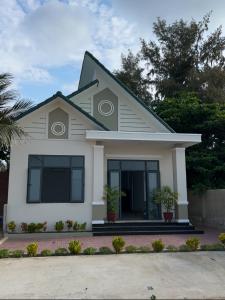 a white house with a black roof at Mơ Homestay - View Biển Ninh Thuận in Thôn Khánh Nhơn