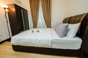 ein Schlafzimmer mit einem Bett mit weißen Laken und Kissen in der Unterkunft Bermaley Bukit Keluang, Besut in Kampung Raja