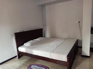 a bedroom with a large bed with white sheets at Villa Surangi in Hikkaduwa