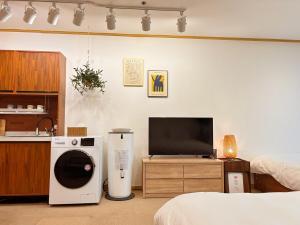 a room with a bed and a tv and a kitchen at 18 Hongik Univ Best location city view in Seoul