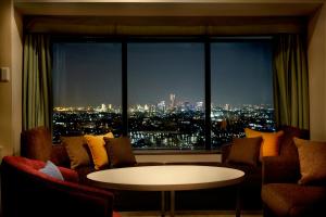 een kamer met een groot raam met een tafel en stoelen bij Shin Yokohama Prince Hotel in Yokohama