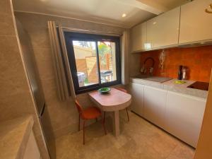 a small kitchen with a table and a window at Studio climatisé - Terrasse, Plancha, Fibre in Aix-en-Provence