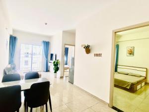 un soggiorno con tavolo, sedie e uno specchio di Kate's house Nha Trang - Apartment 60m2 2BR 2Bath, 5 min to beach a Nha Trang