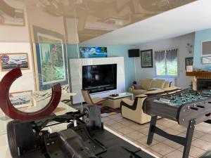 een woonkamer met een groot spelbord in het midden bij L'Olivier Tropical in Muret