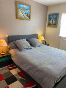 een slaapkamer met een groot bed met twee kussens bij L'Olivier Tropical in Muret