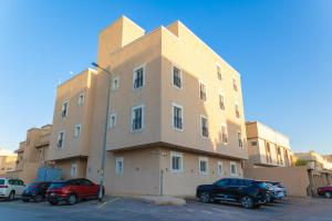 Un gran edificio con coches aparcados en un estacionamiento. en شقه 3فاخره ثلاث غرف نوم, en Riad