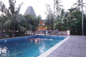 a swimming pool with a fountain in a resort at Mega Resort Karimunjawa in Karimunjawa