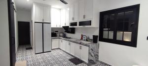 a kitchen with white cabinets and a black and white tile floor at Akasea Sojourn in Jitra