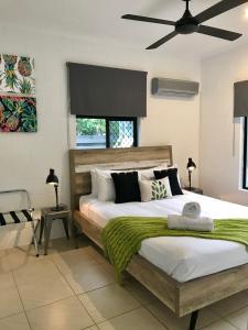a bedroom with a large bed and a ceiling fan at Sandy Feet Retreat - 50m from Four Mile Beach in Port Douglas
