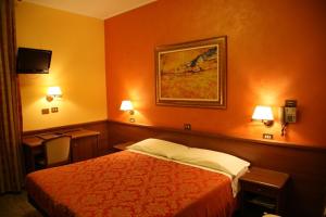 una camera d'albergo con un letto e una foto appesa alla parete di Hotel San Pellegrino a Spilamberto