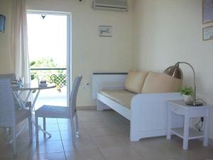 a living room with a white couch and a table at Porto View Suites and Apartments in Porto Heli