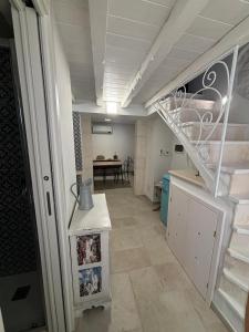 a hallway with a staircase in a room with a table at Casetta Arco Casavola in Martina Franca +11 photos