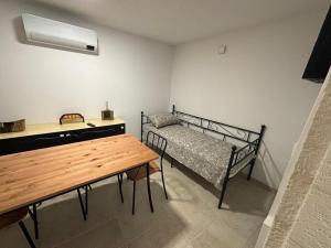 a room with a bed and a table and a bench at Casetta Arco Casavola in Martina Franca