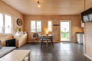 a kitchen with a table and chairs in a room at Karkonoskie Sny - Domki z widokiem na Karkonosze in Wojcieszyce