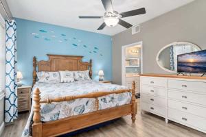 a bedroom with a bed and a ceiling fan at Harbor Hideaway 1 Block to Beach AC in Hampton