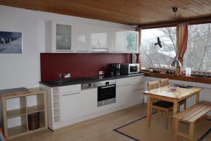 a kitchen with white cabinets and a wooden table at Appartement Ginschel in Altenmarkt im Pongau