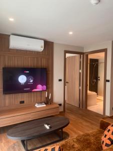 a living room with a flat screen tv on a wall at Spacious Bedroom- 2 mins from Train Station in Bangkok