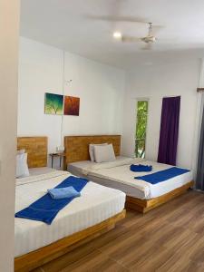 two beds in a bedroom with blue towels on them at Sweet Time Bungalows in Koh Rong Sanloem