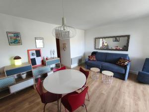 ein Wohnzimmer mit einem Tisch und einem blauen Sofa in der Unterkunft Appartement T2 Bord de Mer - Maria Beach in Santa-Lucia-di-Moriani + 39 Fotos