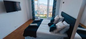 a bed in a room with a large window at Nice, vue mer et panoramique in Nice