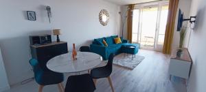 a living room with a table and a blue couch at Nice, vue mer et panoramique in Nice