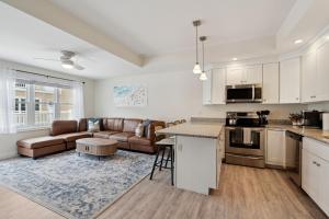 een keuken en woonkamer met een bank en een tafel bij Ashworth Escape Balcony Steps to Beach AC in Hampton +45 foto's