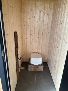 a small bathroom with a toilet in a wooden wall at Glamping 't Hoveke in Gullegem